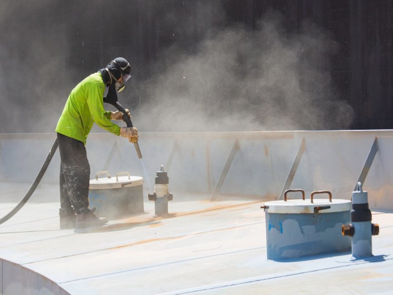 Male worker surface corrosion plate preparation by sand blasting of tank top deck pontoon.
